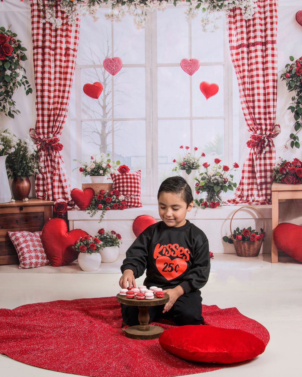 Valentine's day themed room with red and white checkered curtains, heart decorations, and plush cushions on a red carpet.