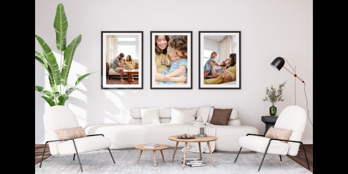 Modern living room wall gallery display with white sectional and houseplants.