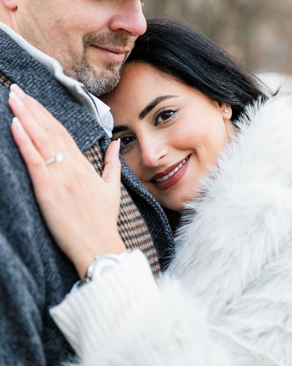 An intimate portrait of a couple in winter attire sharing a romantic moment.