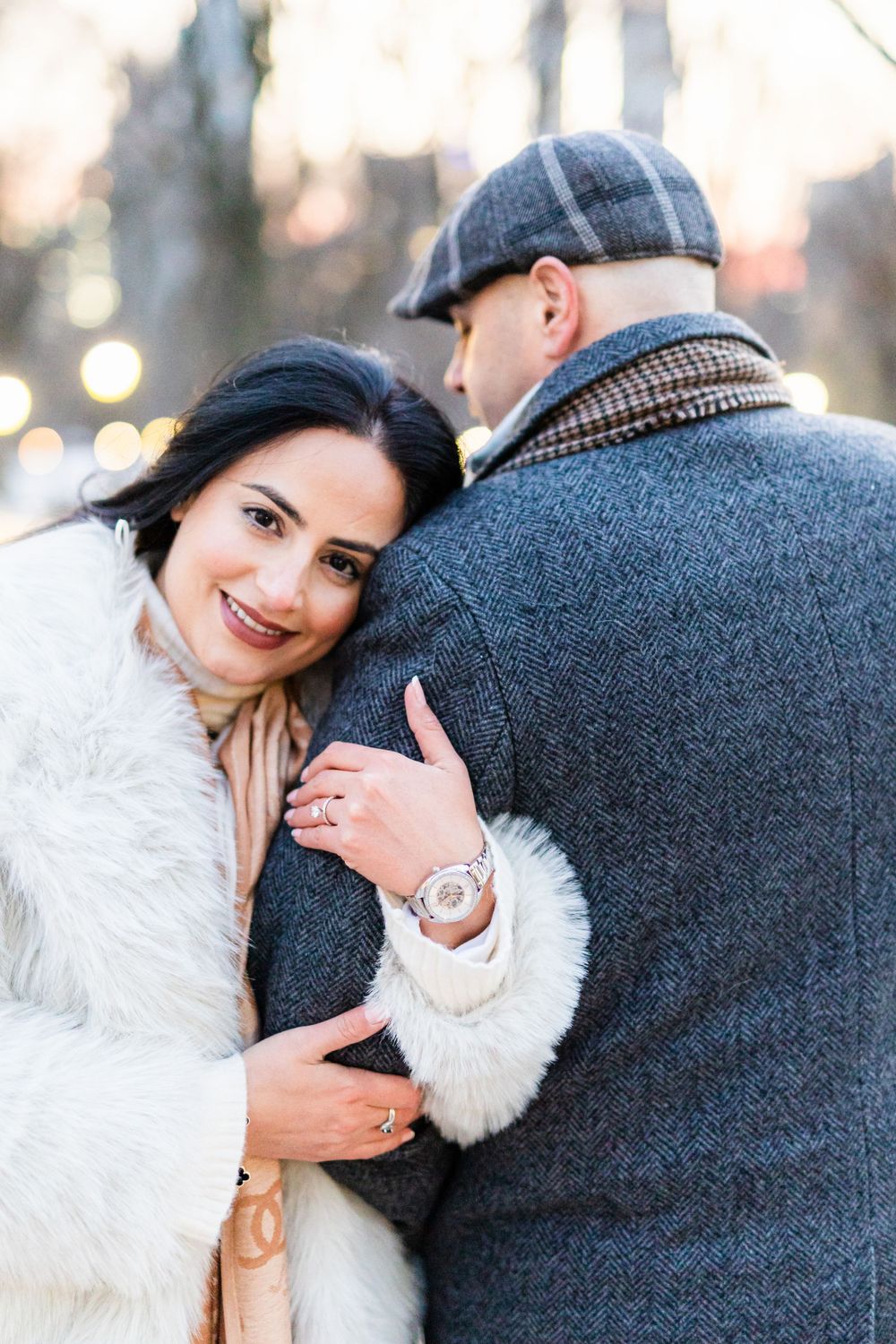 A tender winter engagement photo with cozy sweaters and fur coat.