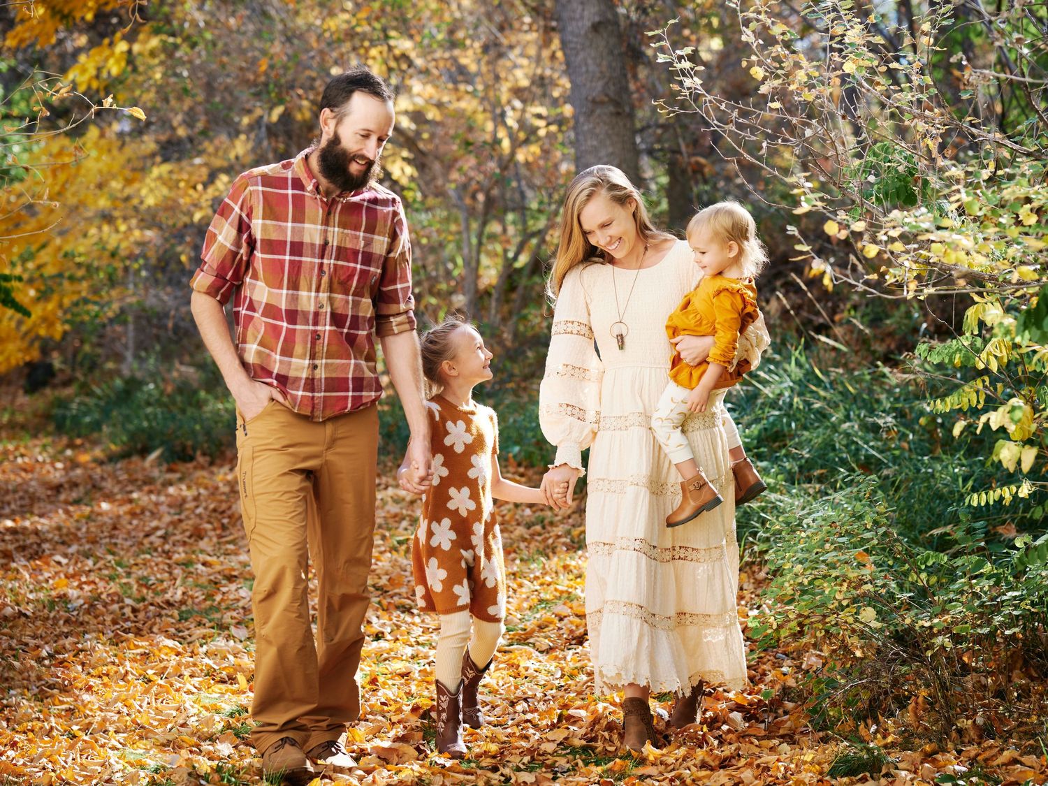 Family enjoying an autumn walk together among colorful fall foliage.