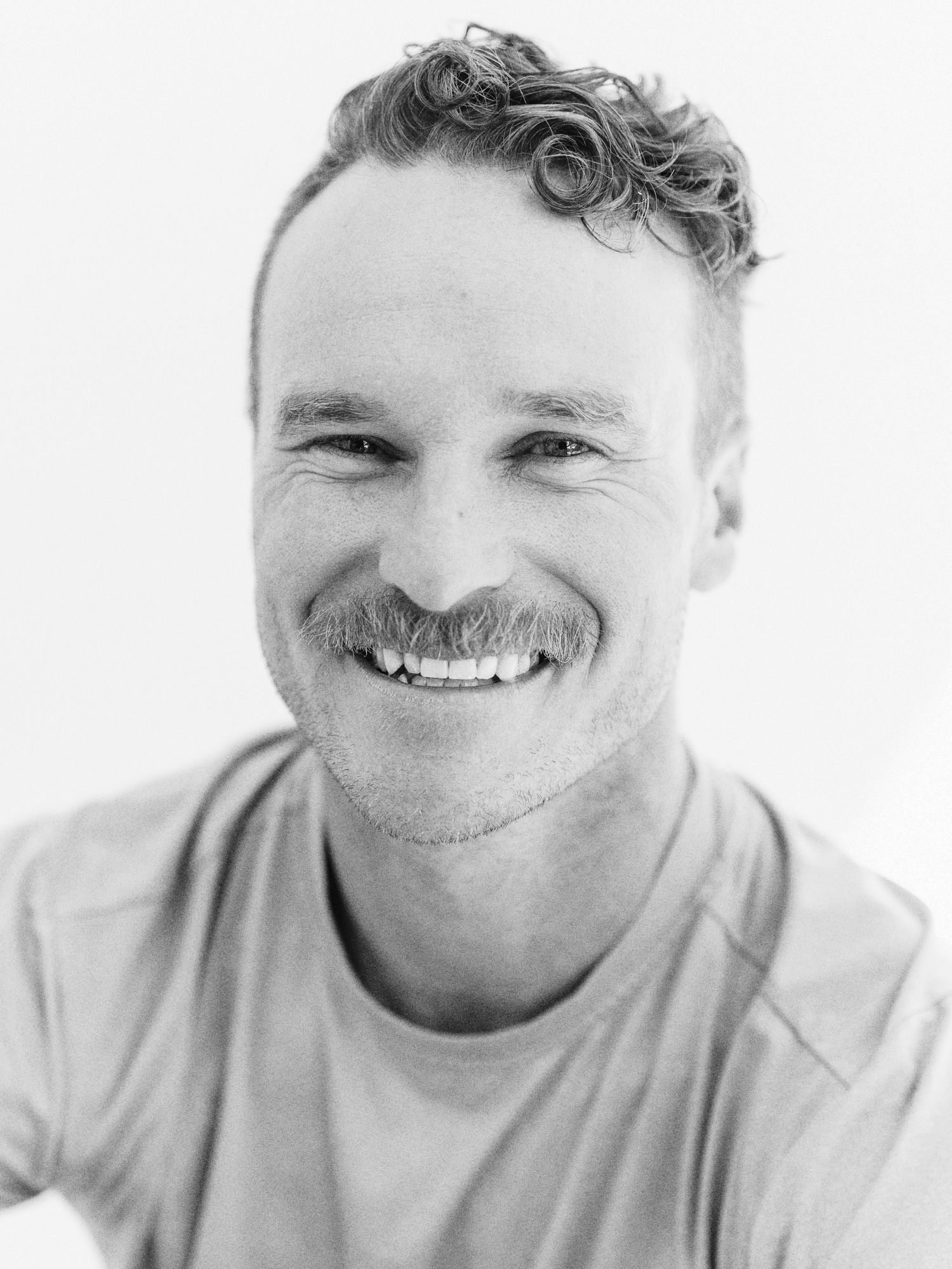 Black and white portrait showing a warm genuine smile.