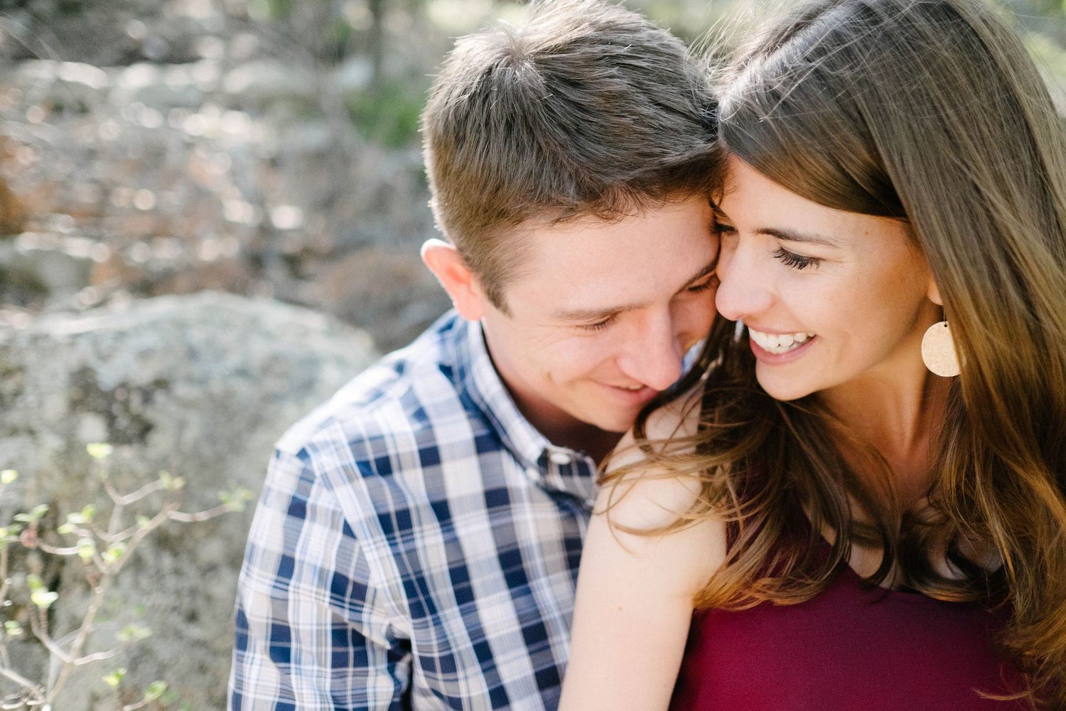 Intimate couple sitting close together outdoors with natural lighting.