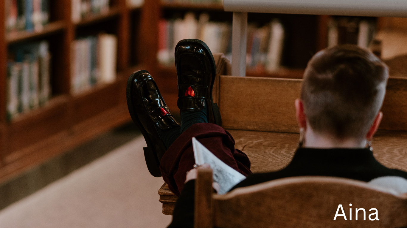 Person holding game controllers in a library setting.