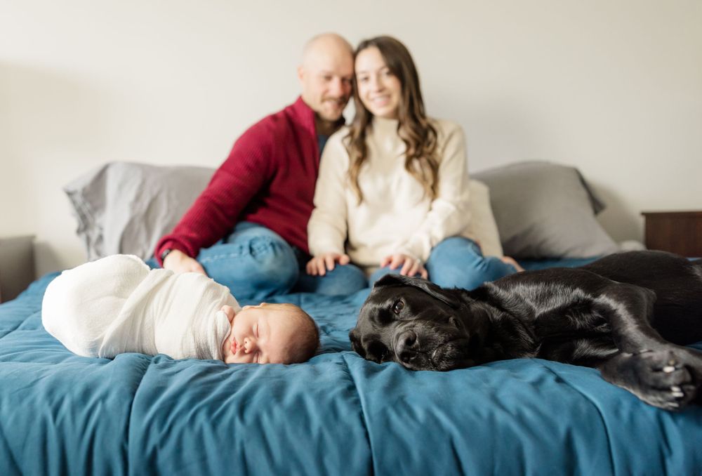 baby and dog at the end of the bed