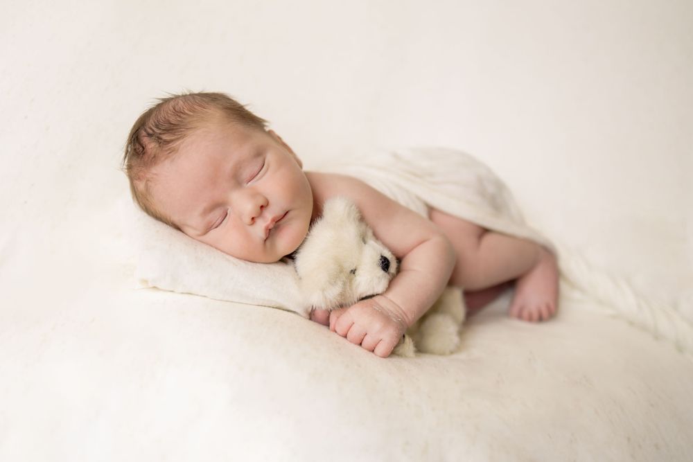 baby holding teddy bear