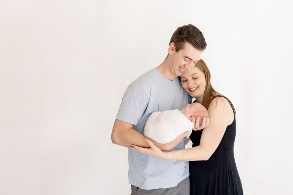 mom and dad holding baby