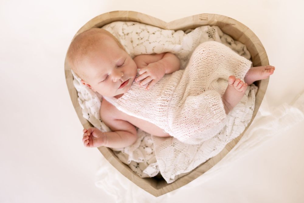 baby sleeping in a heart shaped bowl