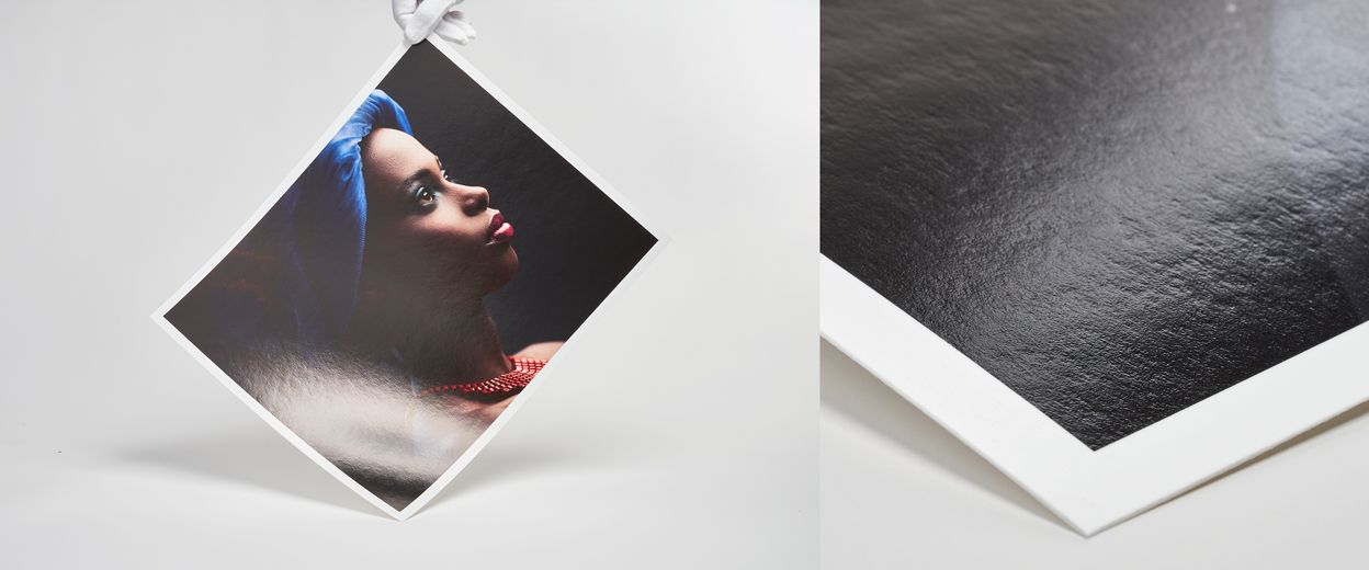 A fine art photo print displayed at an angle showing glossy texture and white border detail.