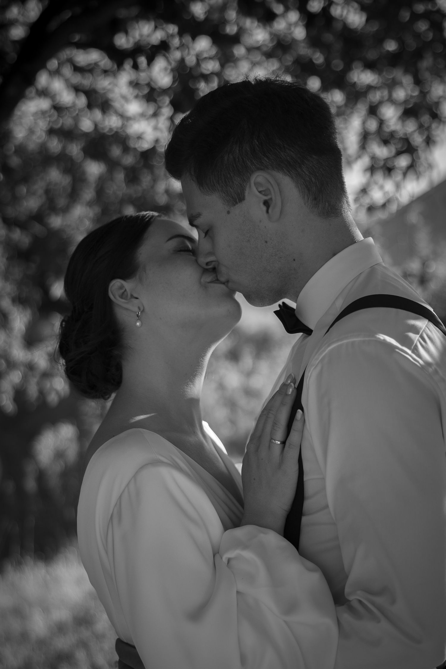 A romantic black and white portrait of a tender moment between newlyweds.