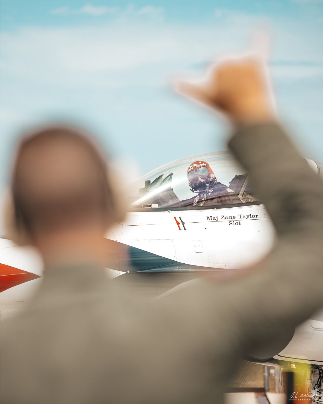 A blurred silhouette waves at a small aircraft on the tarmac.