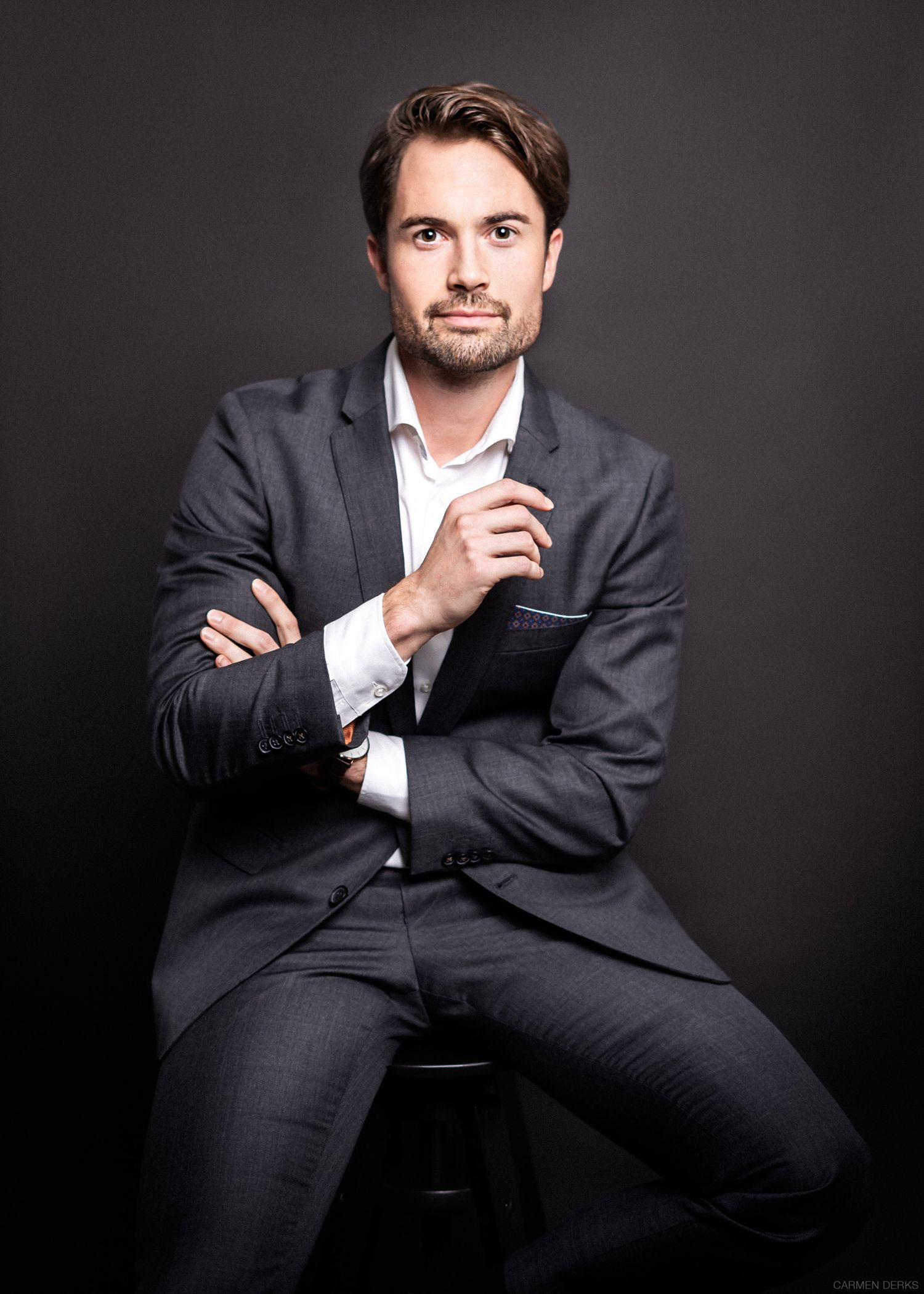 model fotografie van een man in pak zit op kruk voor een professionele business photoshoot, in een studio in beneden-leeuwen, maas en waal