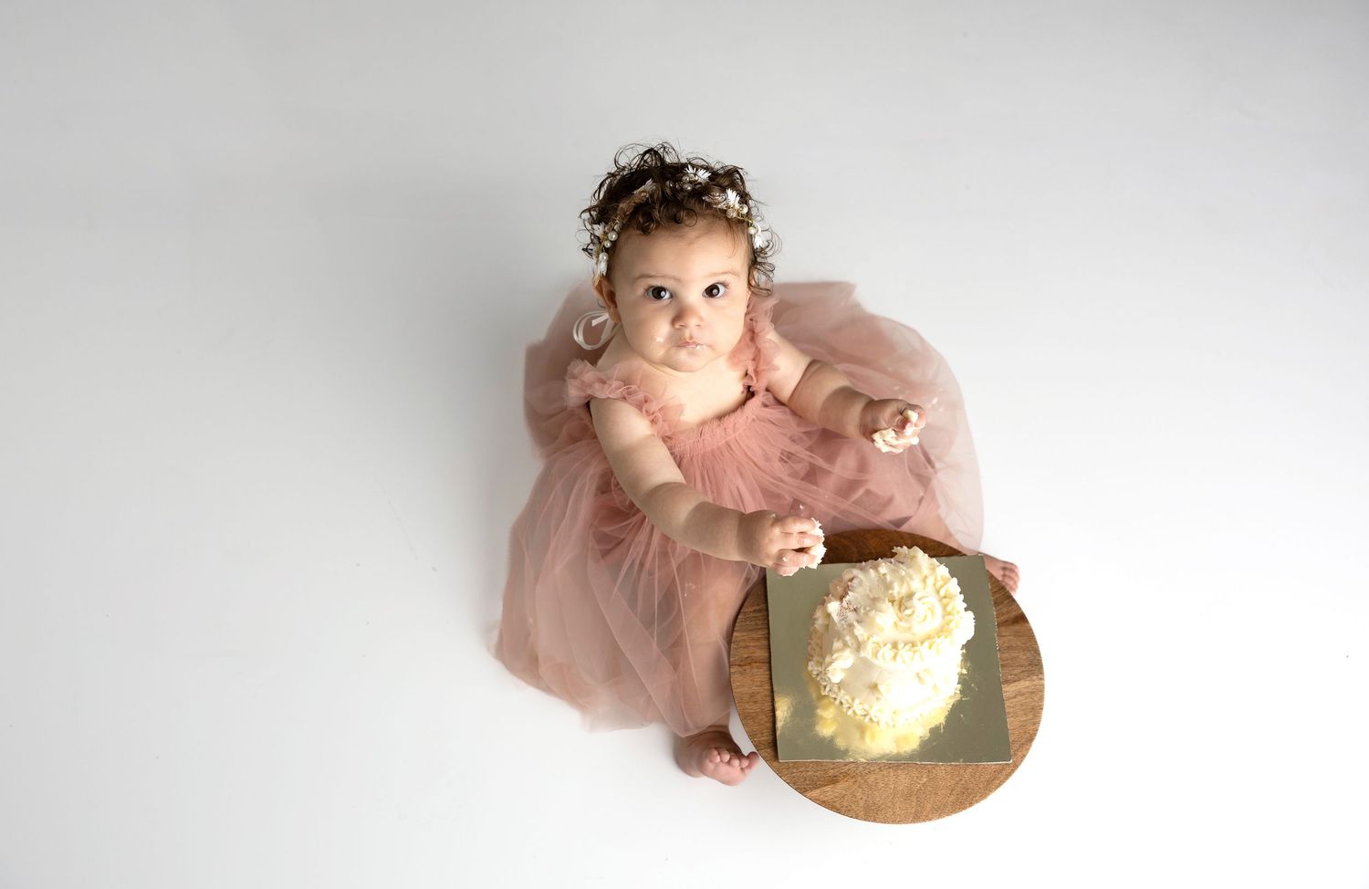 Delicate pink and cream colored baby milestone photos arranged in a row showing growth progression.