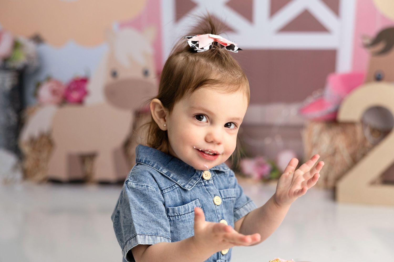 Toddler smiling and playing at party with festive decorations and banners.