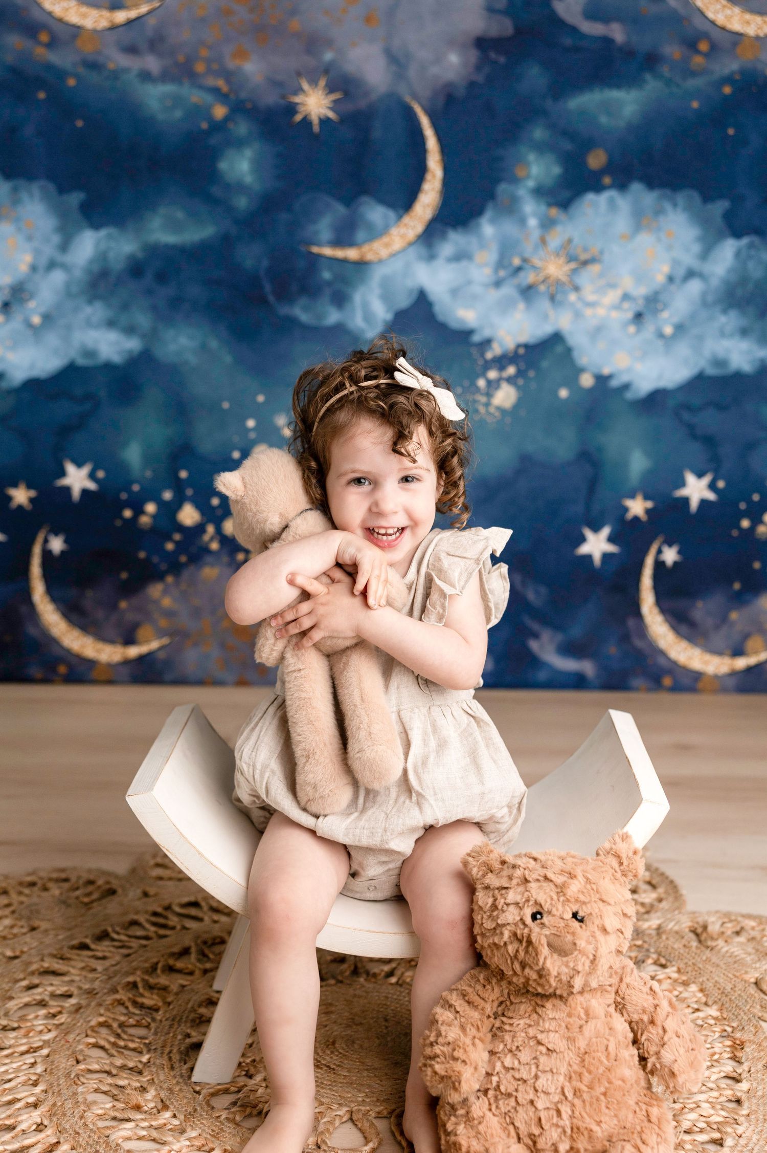 A dreamy portrait session with a teddy bear prop against a magical night sky background.