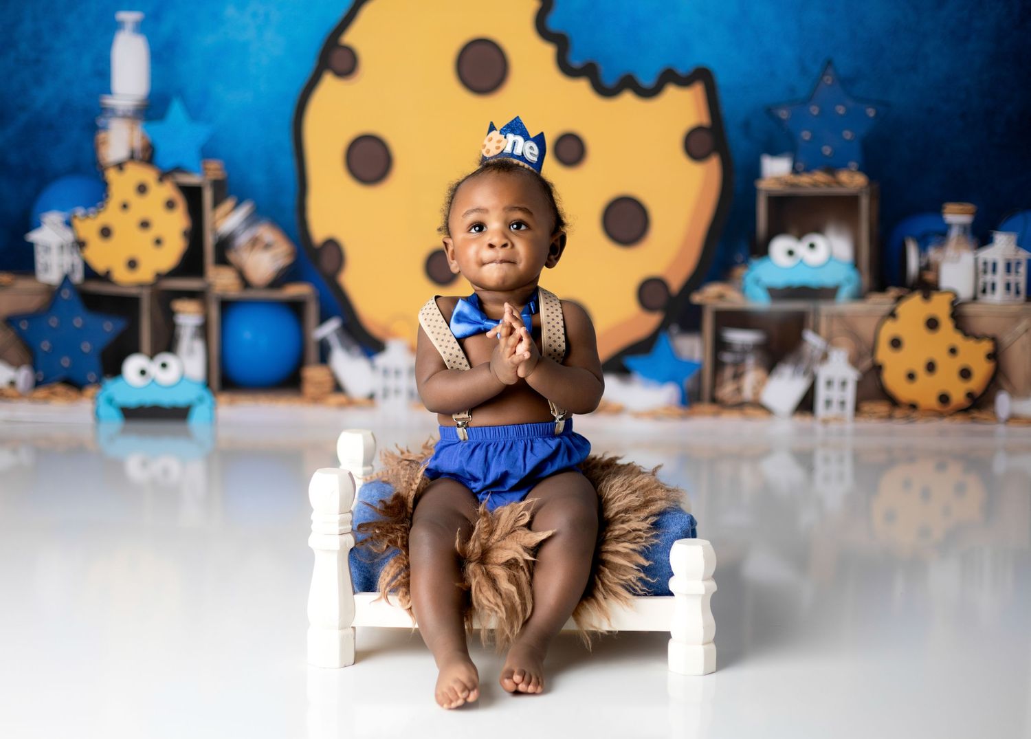 Cookie Monster themed birthday setup with decorated chair and giant cookie backdrop.