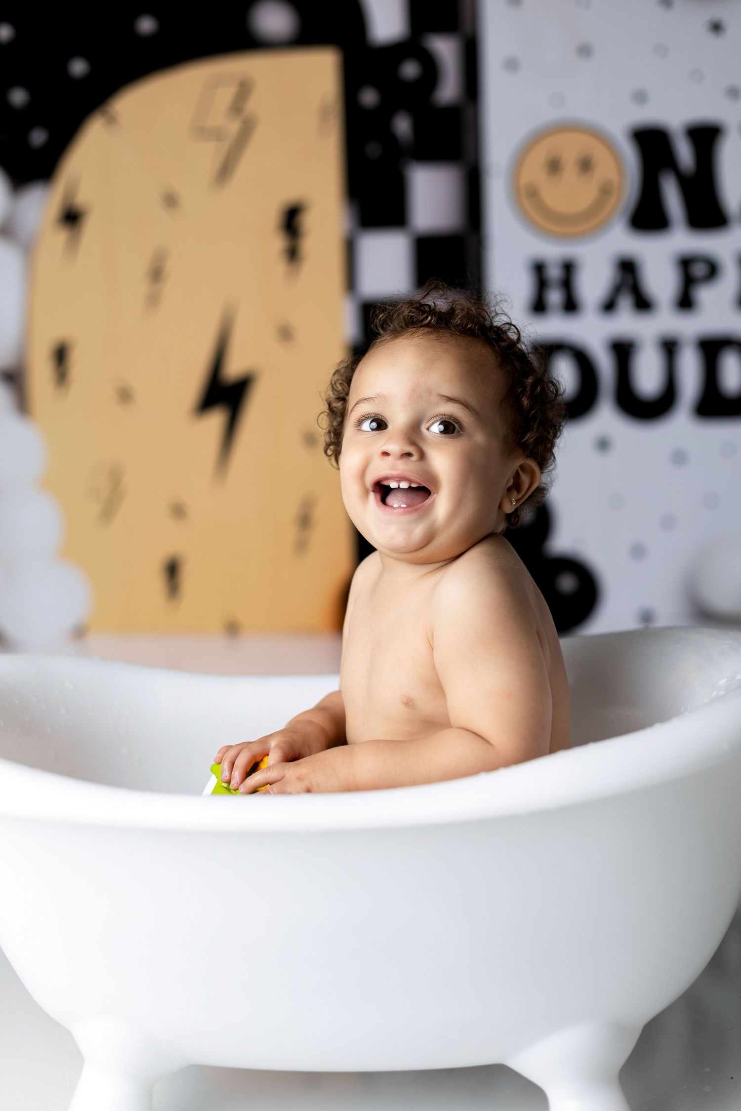 Happy bath time photo with lightning bolt and smiley face decorations in background.
