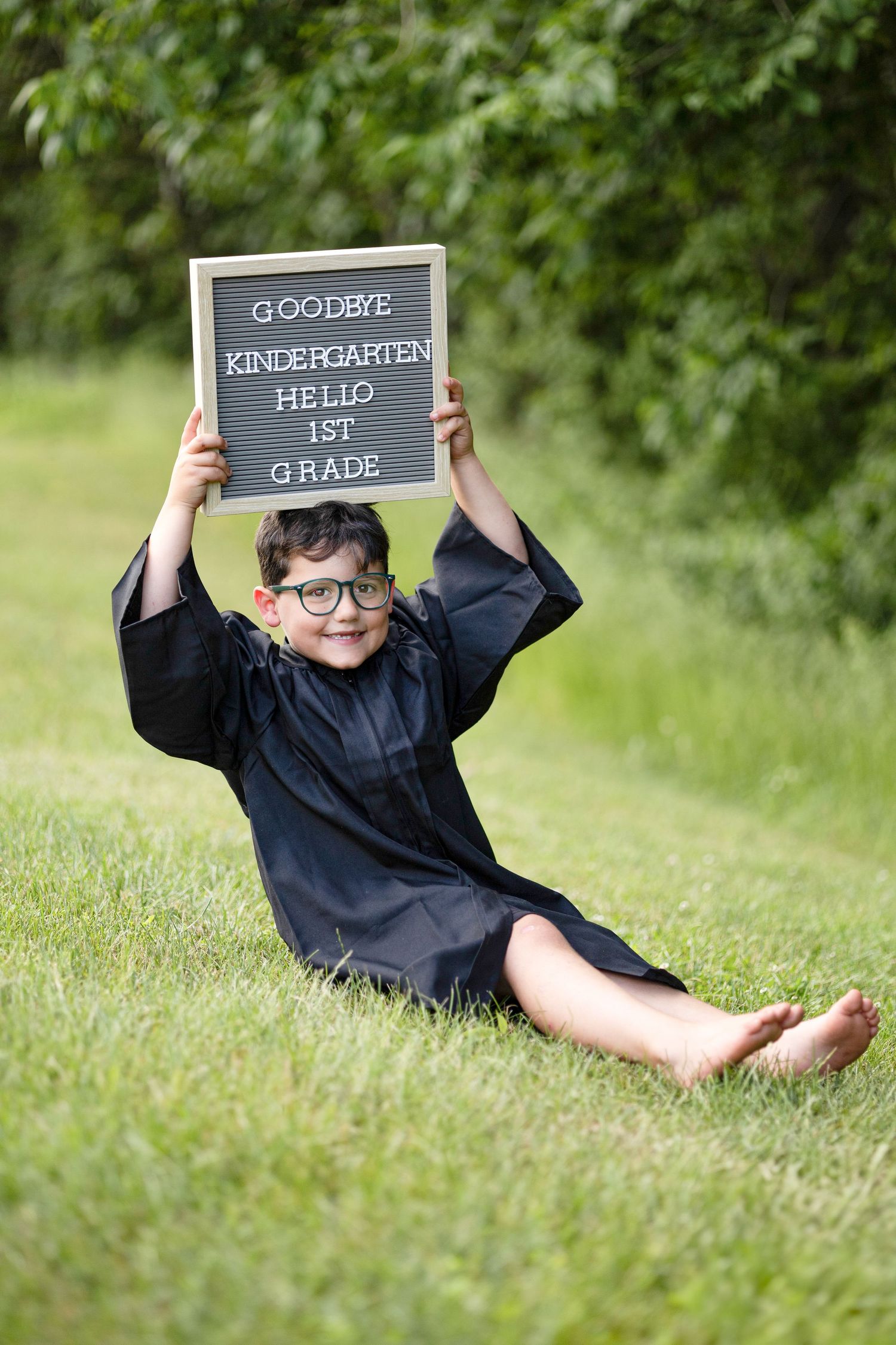 Graduation photos with letter board signs on grass celebrating kindergarten milestone.