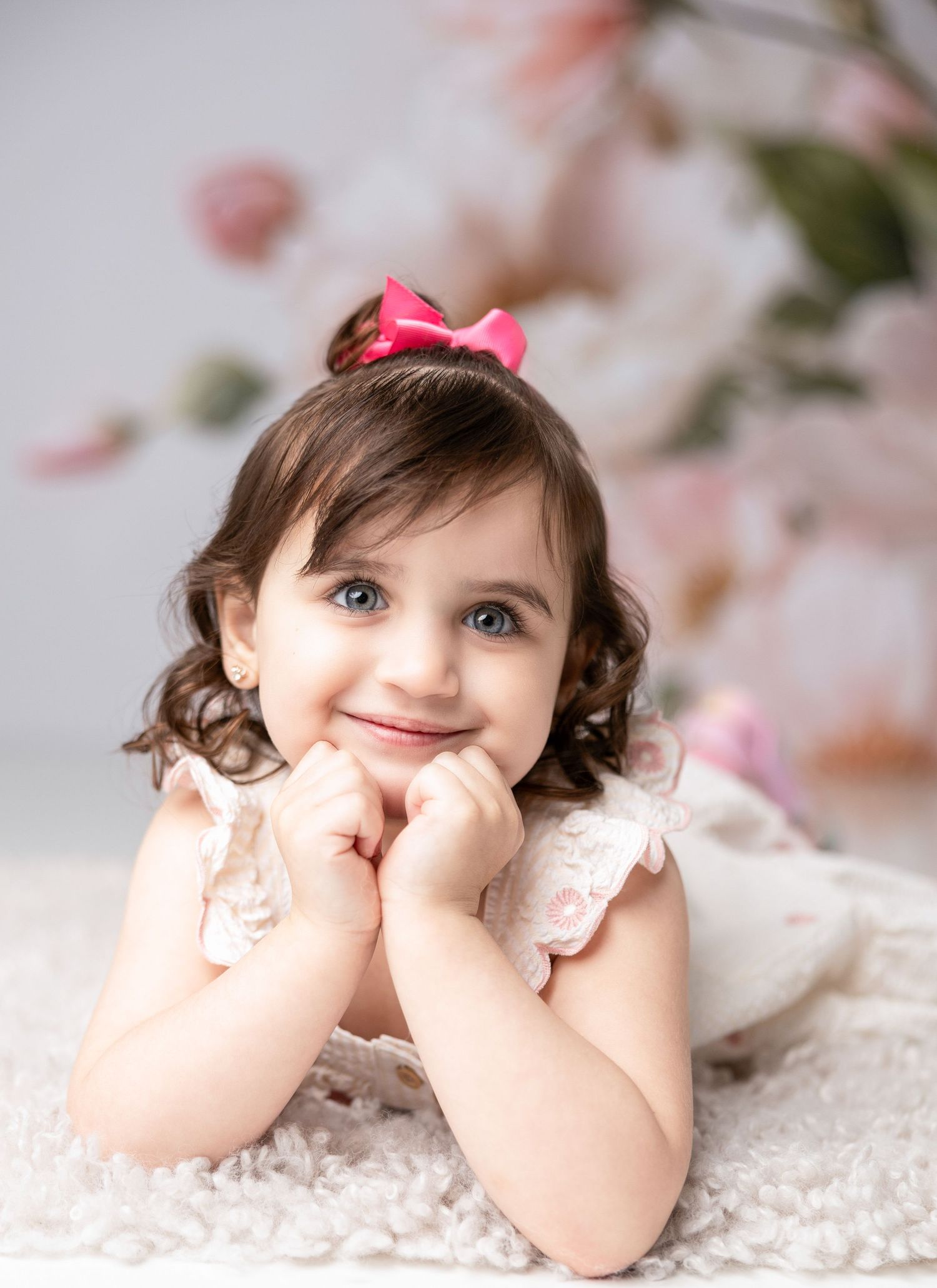 Sweet portrait session with lace backdrop and delicate pink floral details.