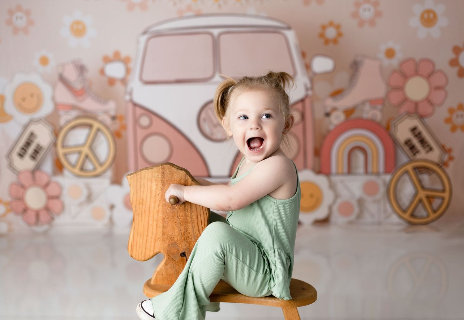 Happy toddler playing on wooden rocking horse with vintage-style background.