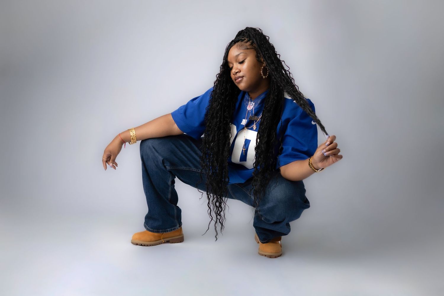 Person in denim outfit striking dynamic poses against grey studio backdrop.