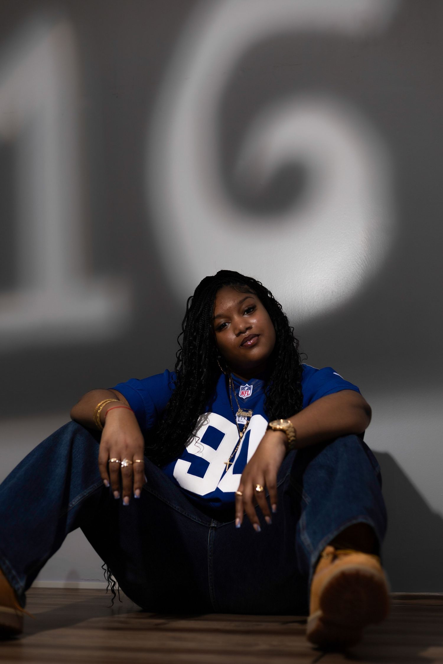 Artistic portrait series in moody lighting featuring person in sports jersey.