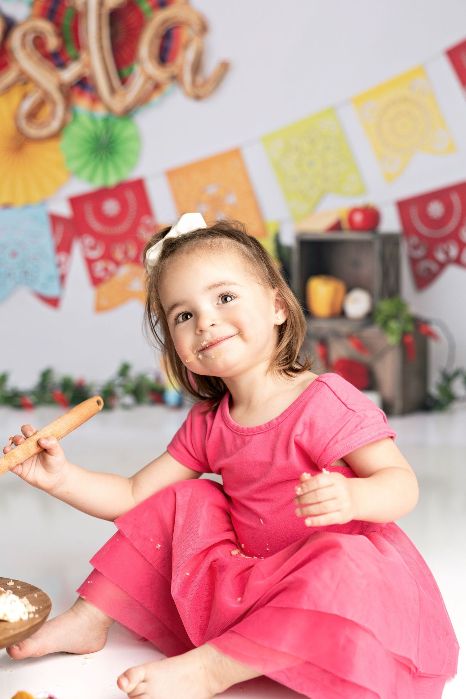 A joyful celebration photoshoot with bright fiesta-themed decorations and cake.