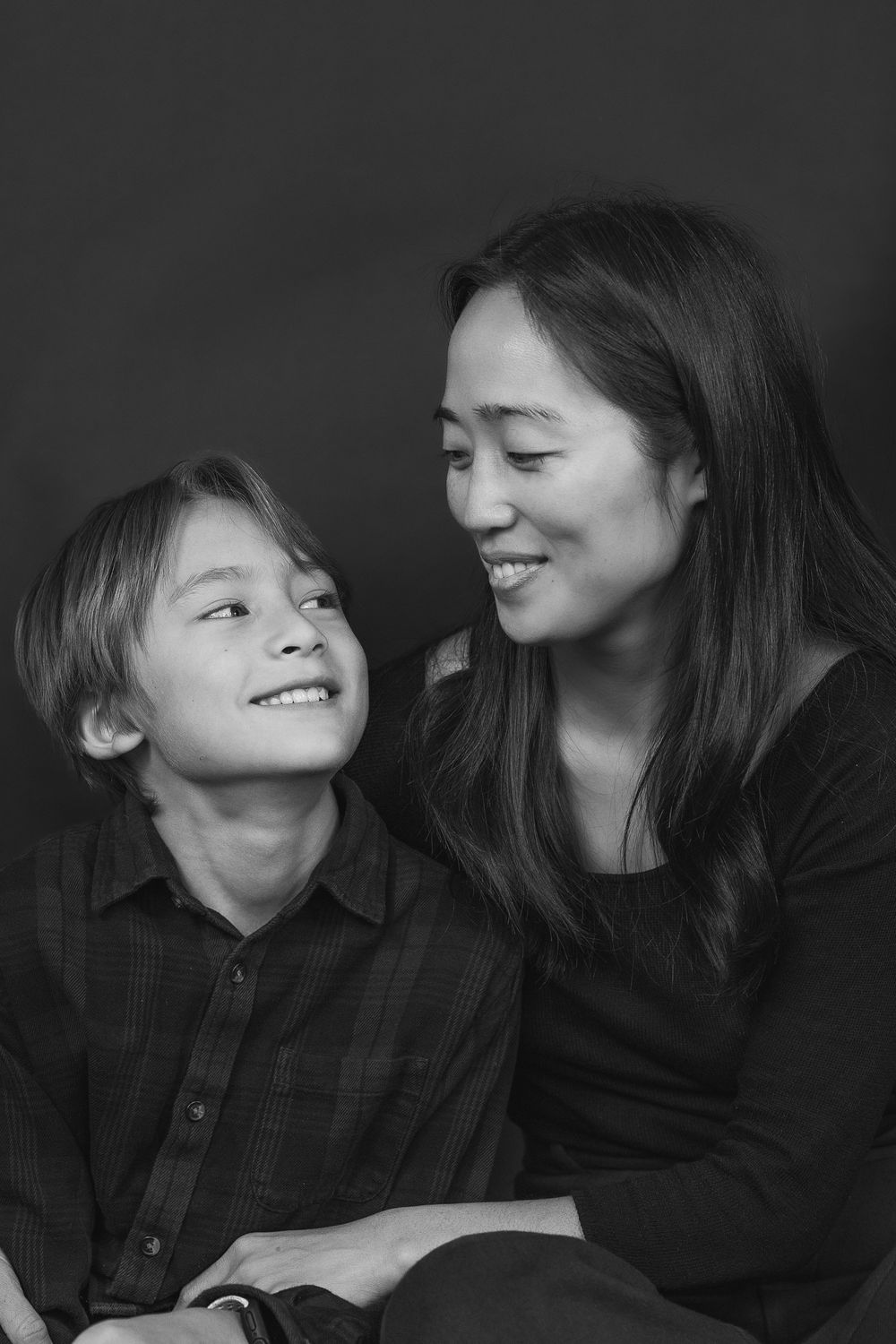 Black and white portrait of a parent and child sharing a candid laughing moment together.