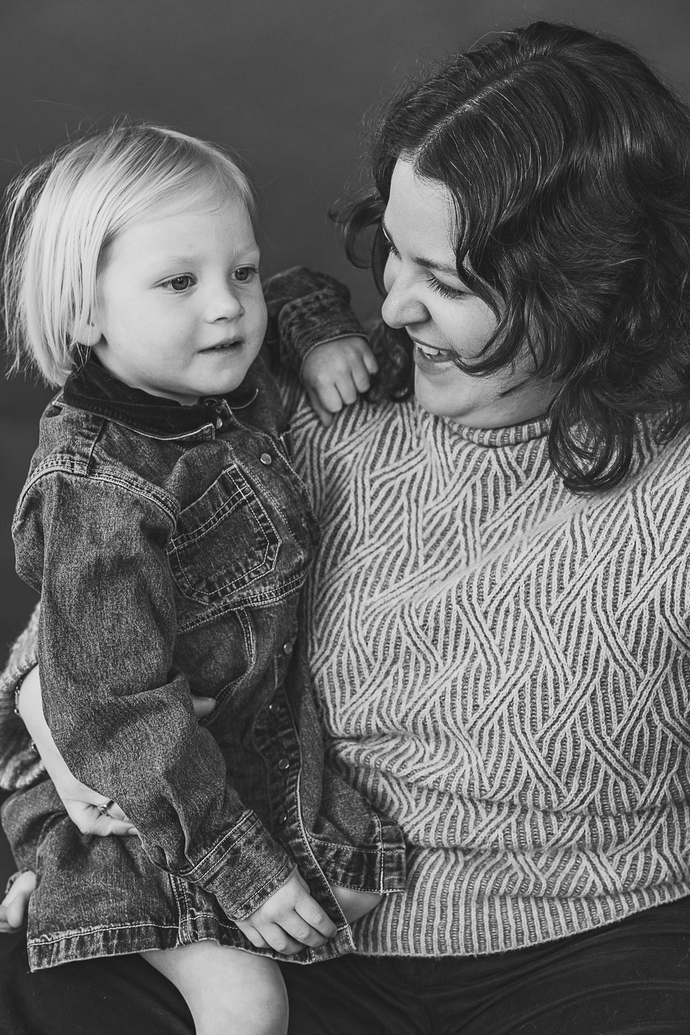 Black and white sequence showing a tender moment between two people in denim and knitwear.