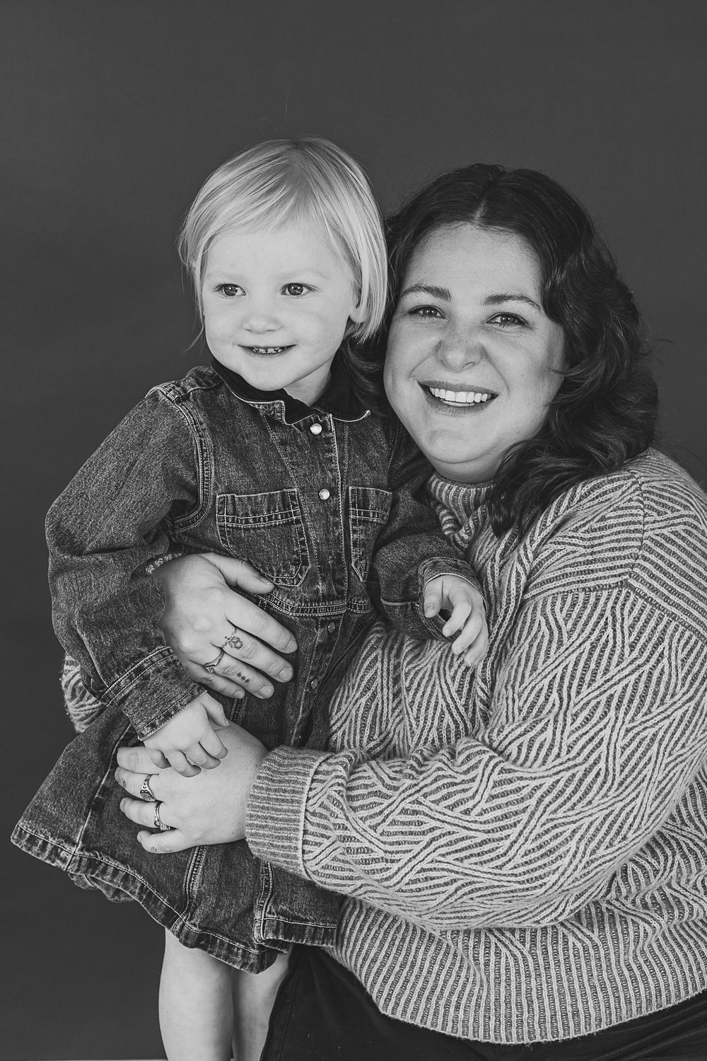 A series of black and white portraits showing tender moments of affection and connection against a dark background.
