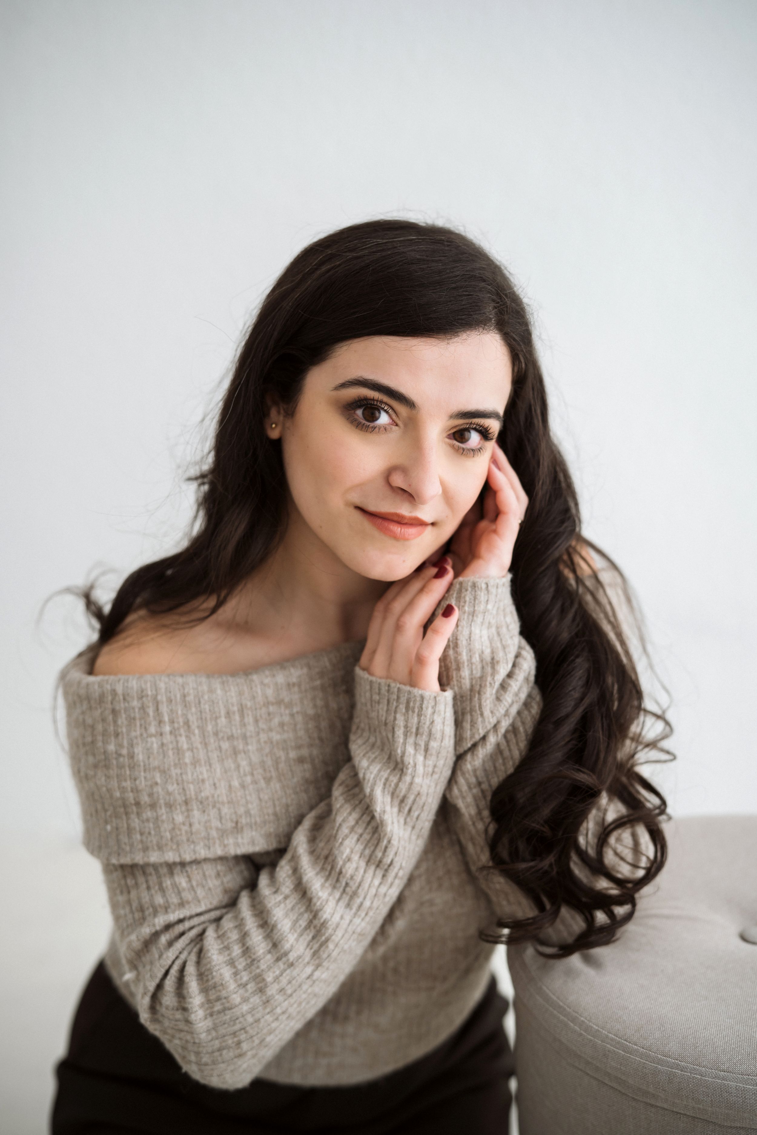 Portrait series in soft beige sweater against white background.