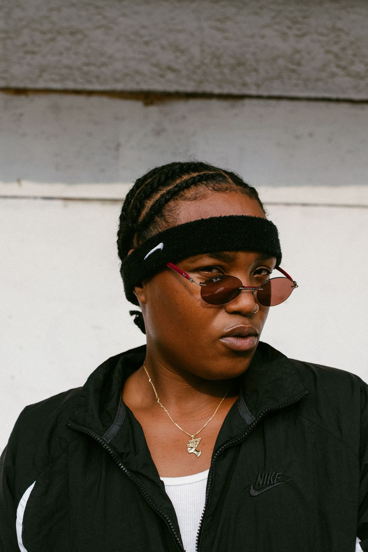 Urban portrait featuring Nike apparel, headband and stylish sunglasses.