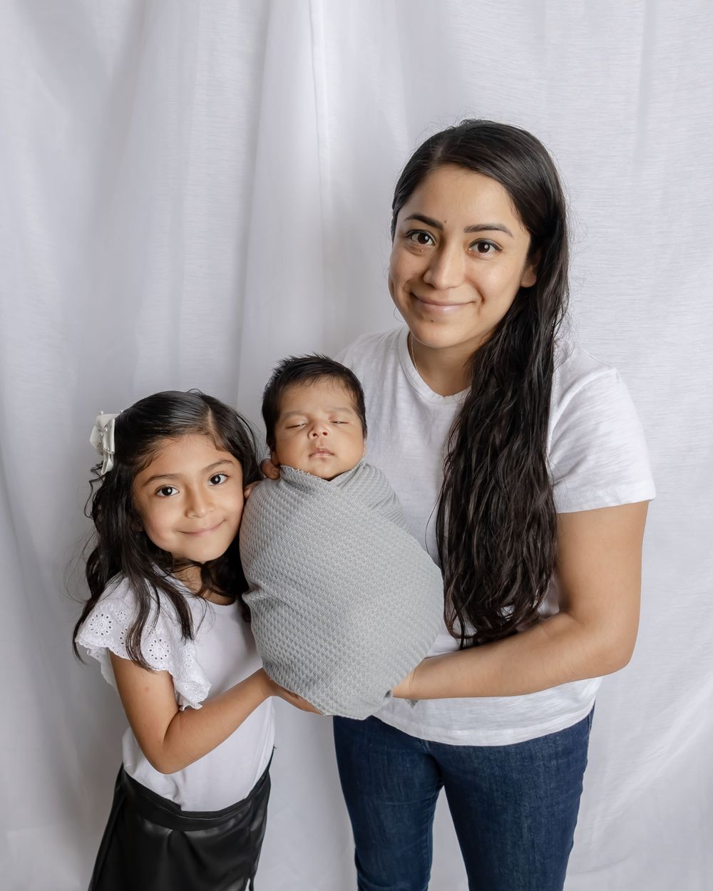 Family studio portrait against white background showing three generations together.
