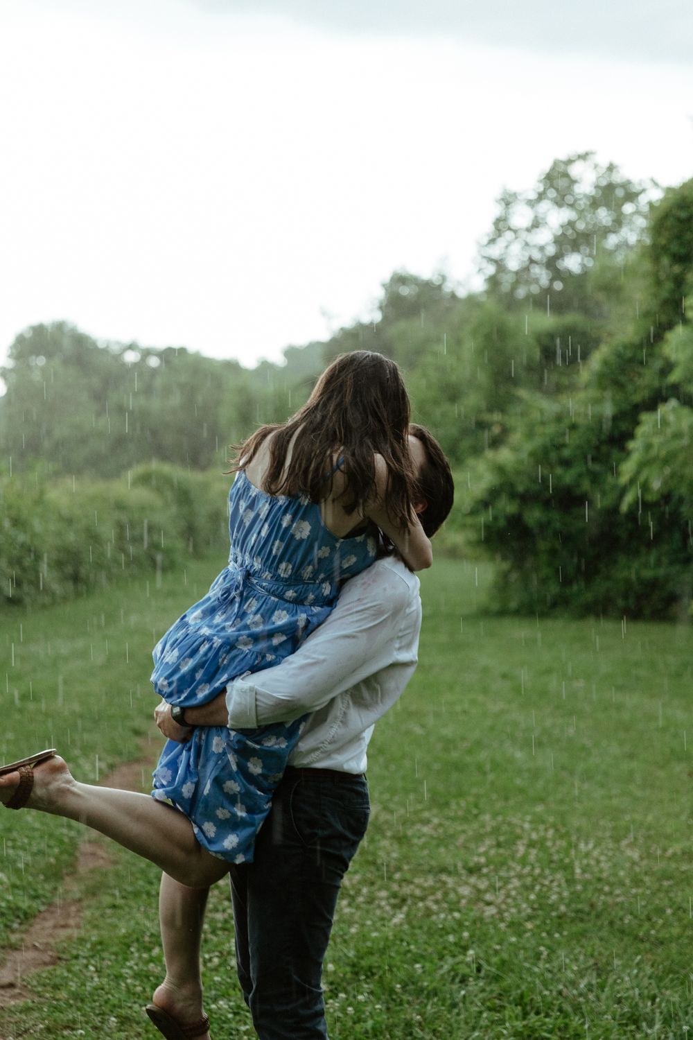 Couple playing and laughing together in a wildflower meadow.