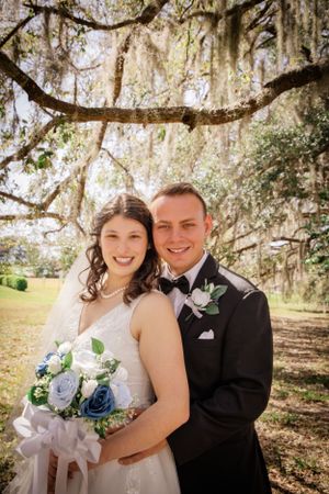 Wedding portraits captured under beautiful moss-draped trees in natural lighting.