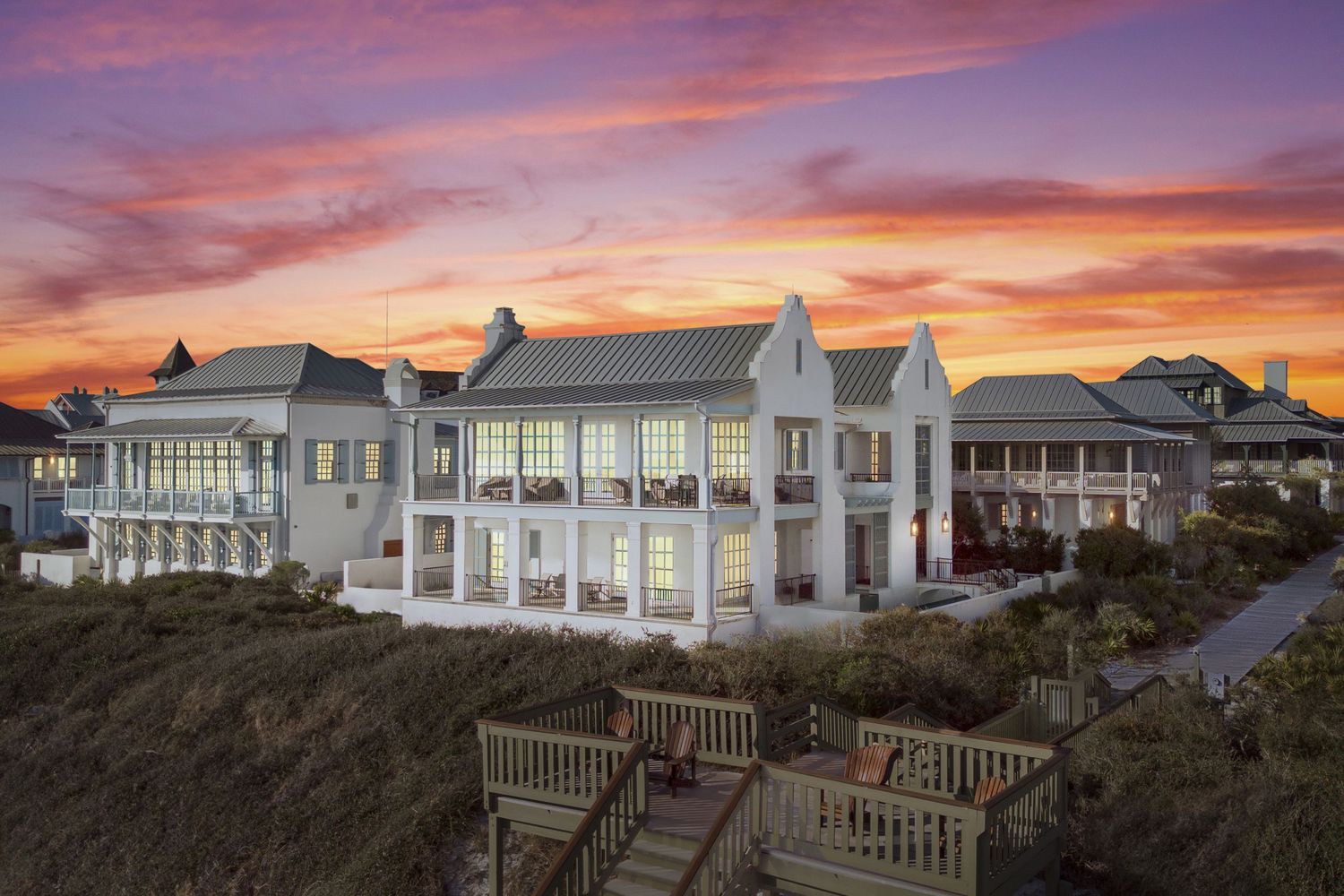 Aerial view of a home in Rosemary Beach, FL, bathed in the warm hues of a sunset sky. Real Estate Photography