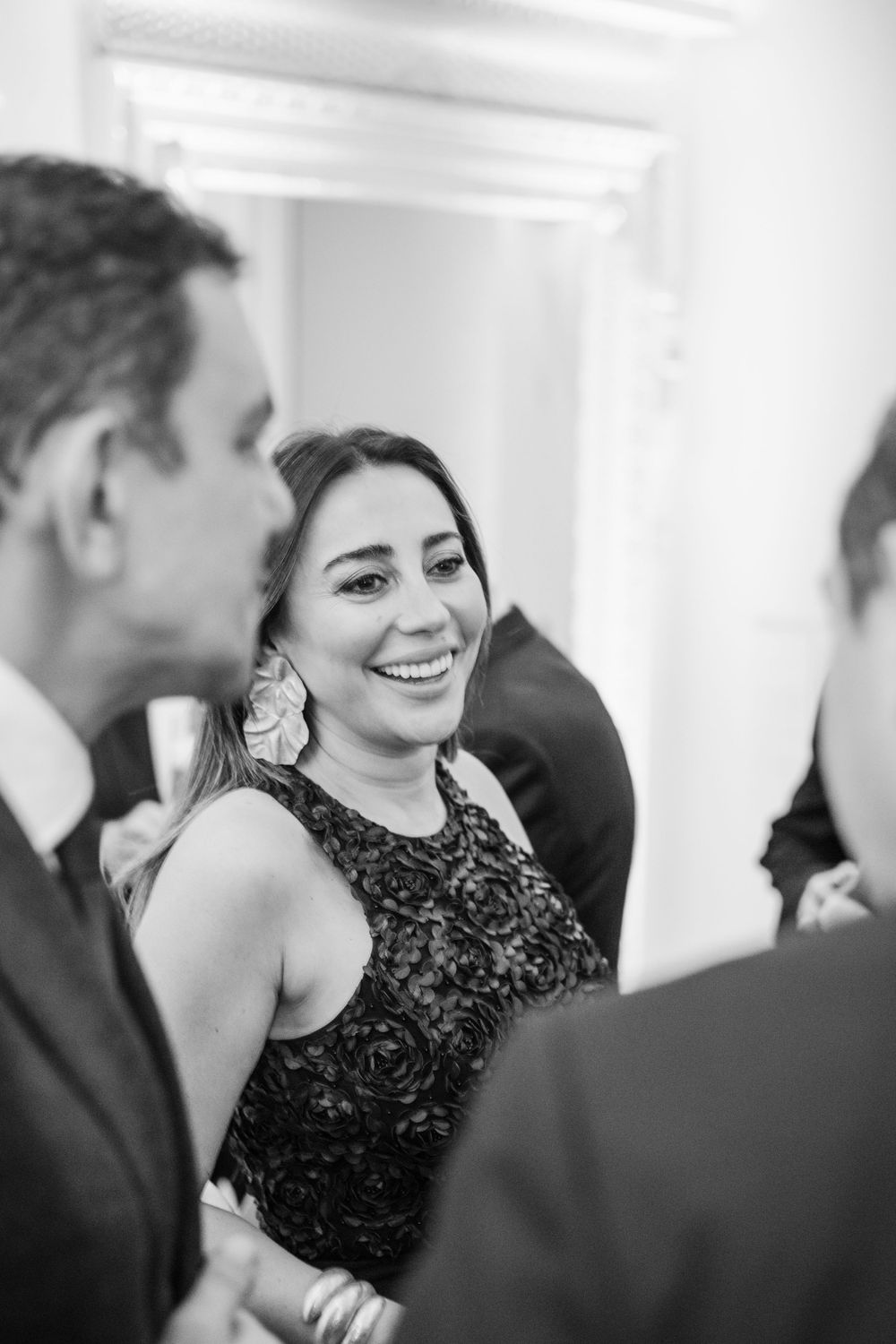 A candid black and white photo showing joyful laughter during an elegant formal event.