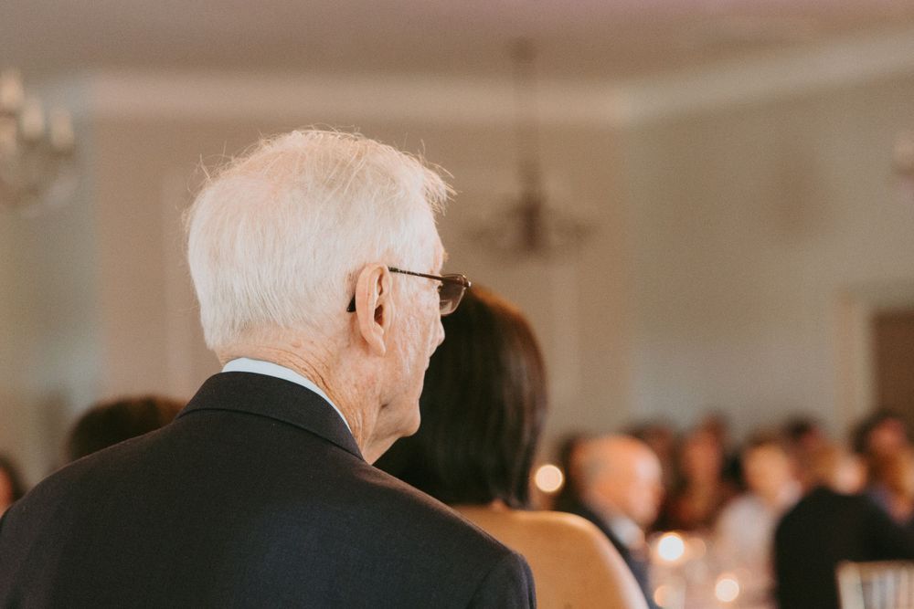 Side view of a guest watching a ceremony in an indoor venue.