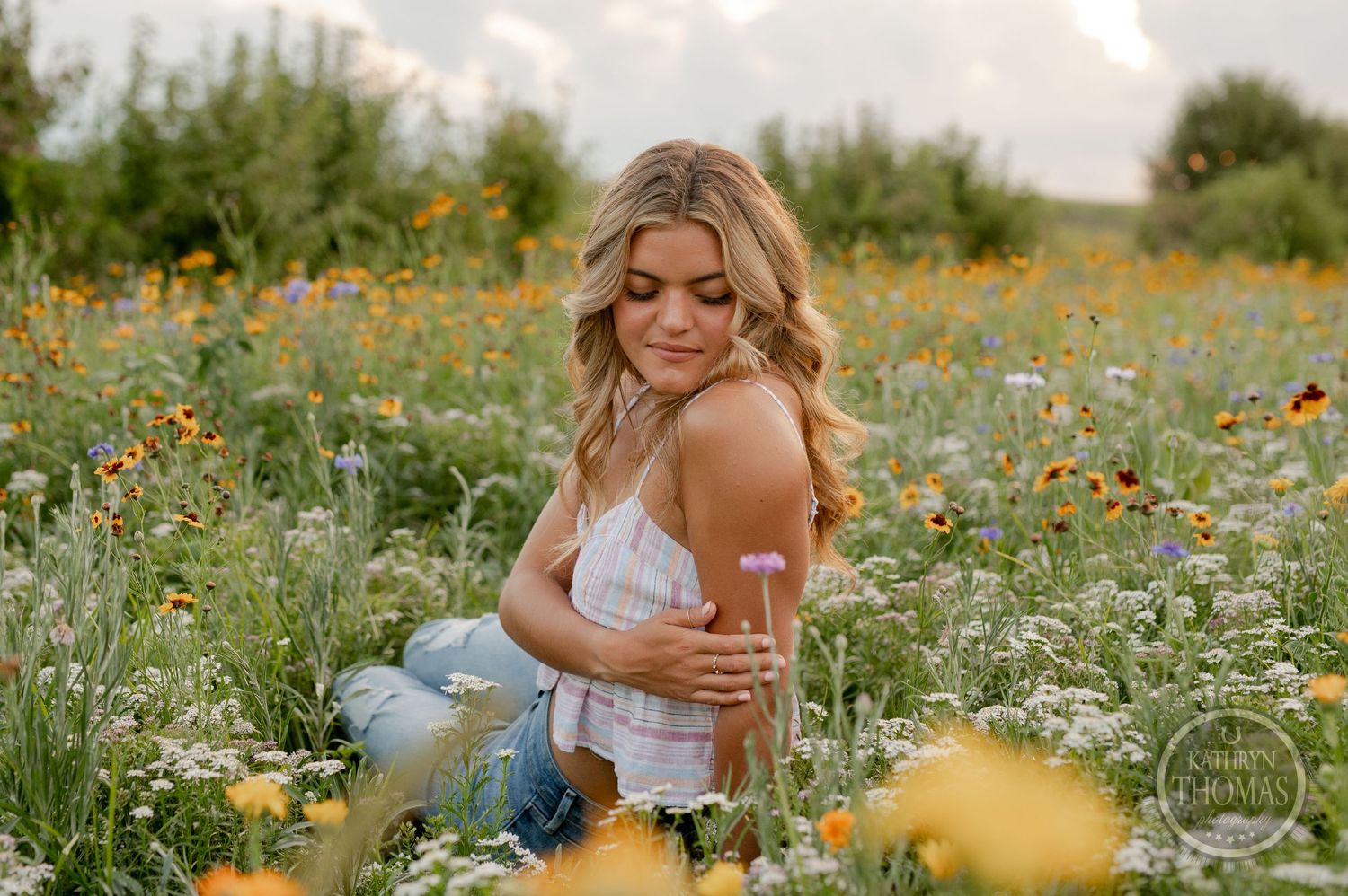 Candid lifestyle portrait among colorful wildflowers in a summer meadow.