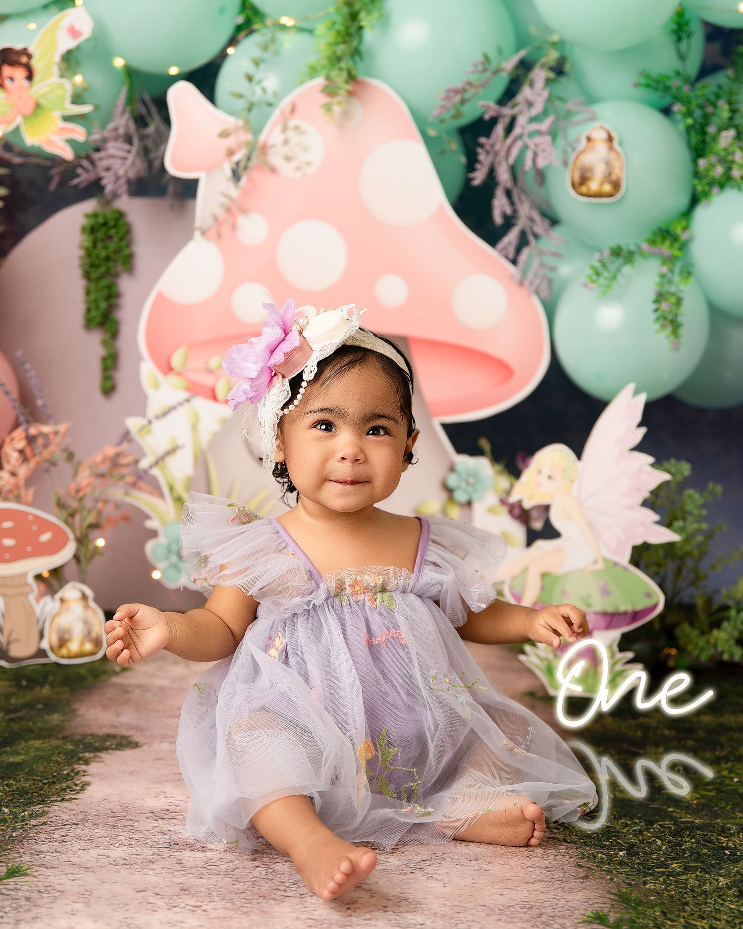 Tropical themed first birthday photo with character cutouts and beach backdrop.