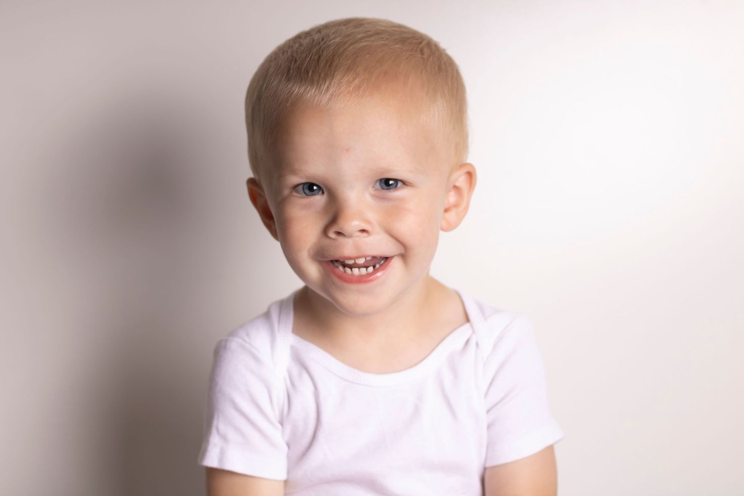A young boy smiles at the camera