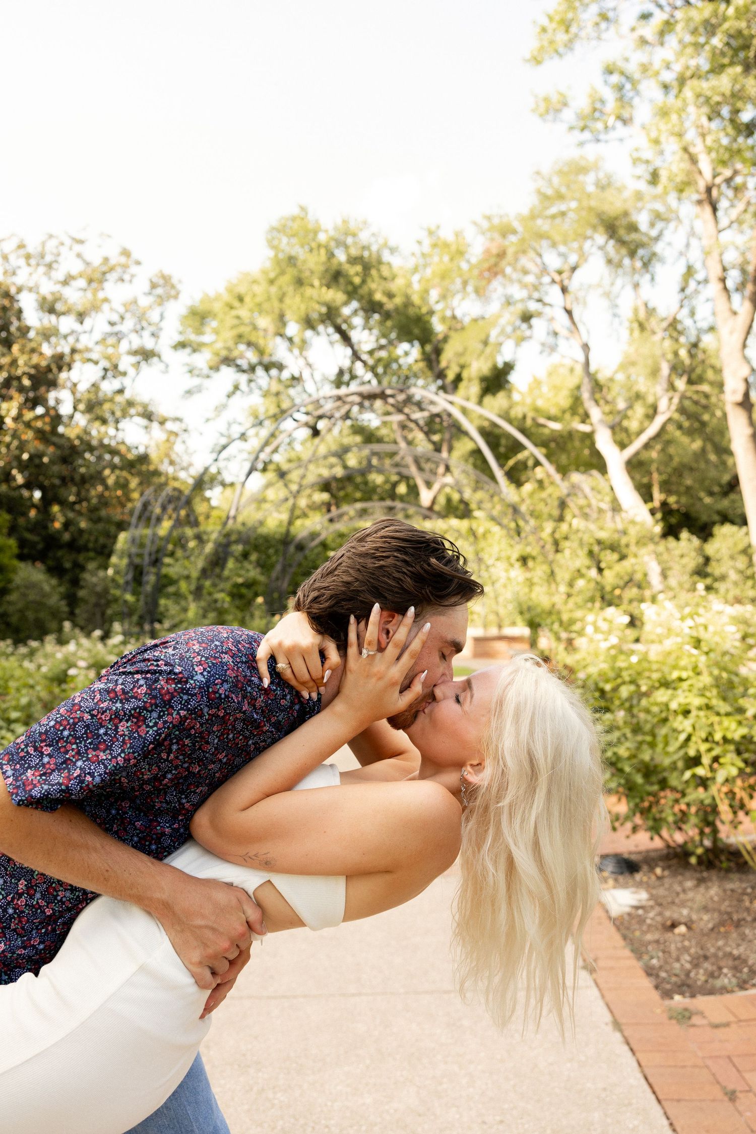 A romantic couple sharing an intimate moment outdoors in summer.