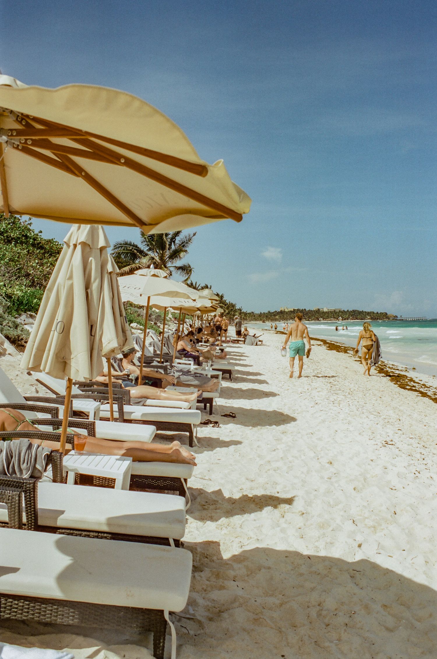 Beach umbrellas and lounge chairs line a pristine white sand beach.