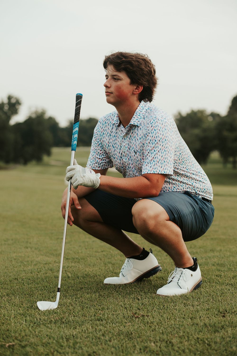 boy posing with golf club