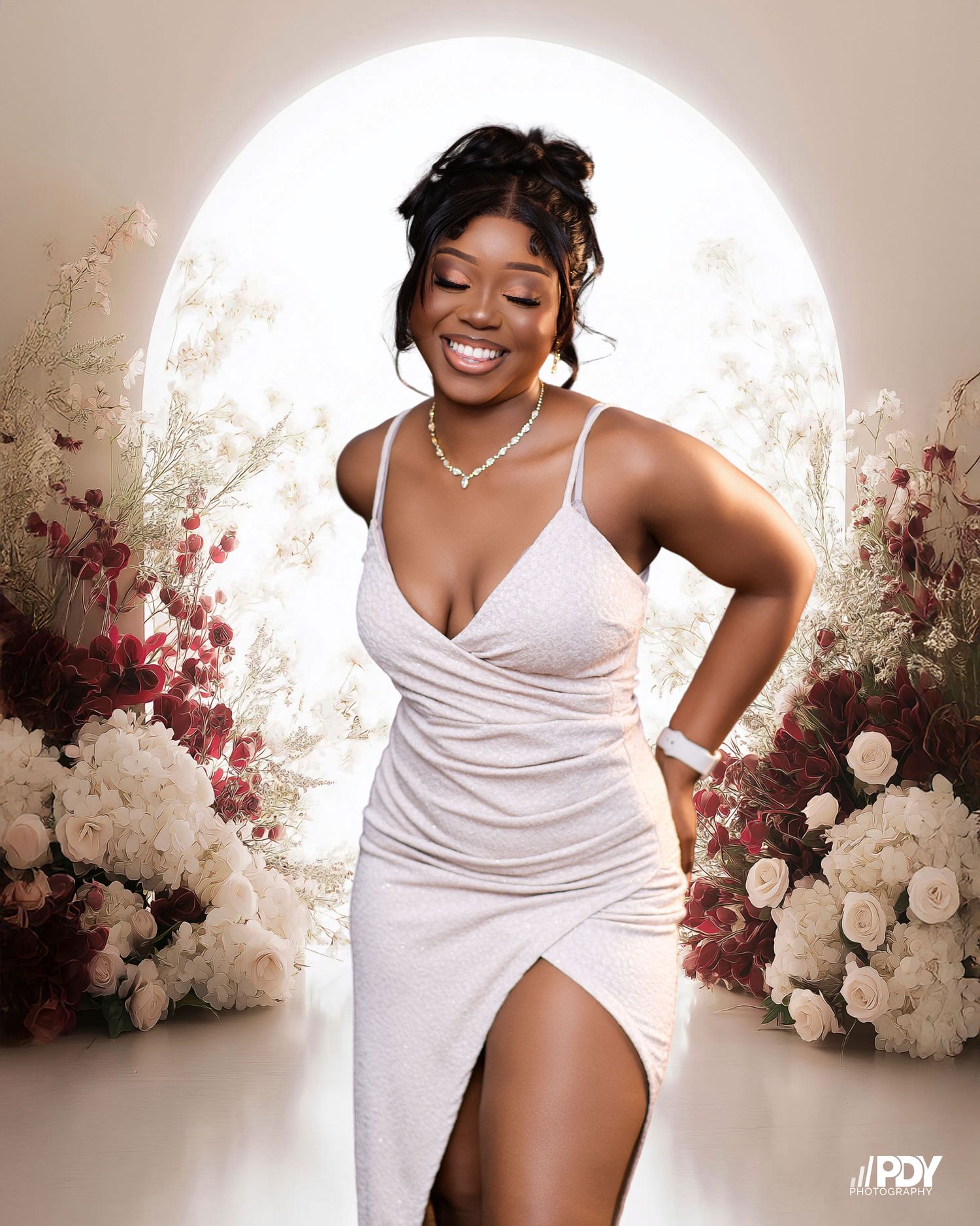 Elegant boudoir photoshoot with white flowers and soft lighting.