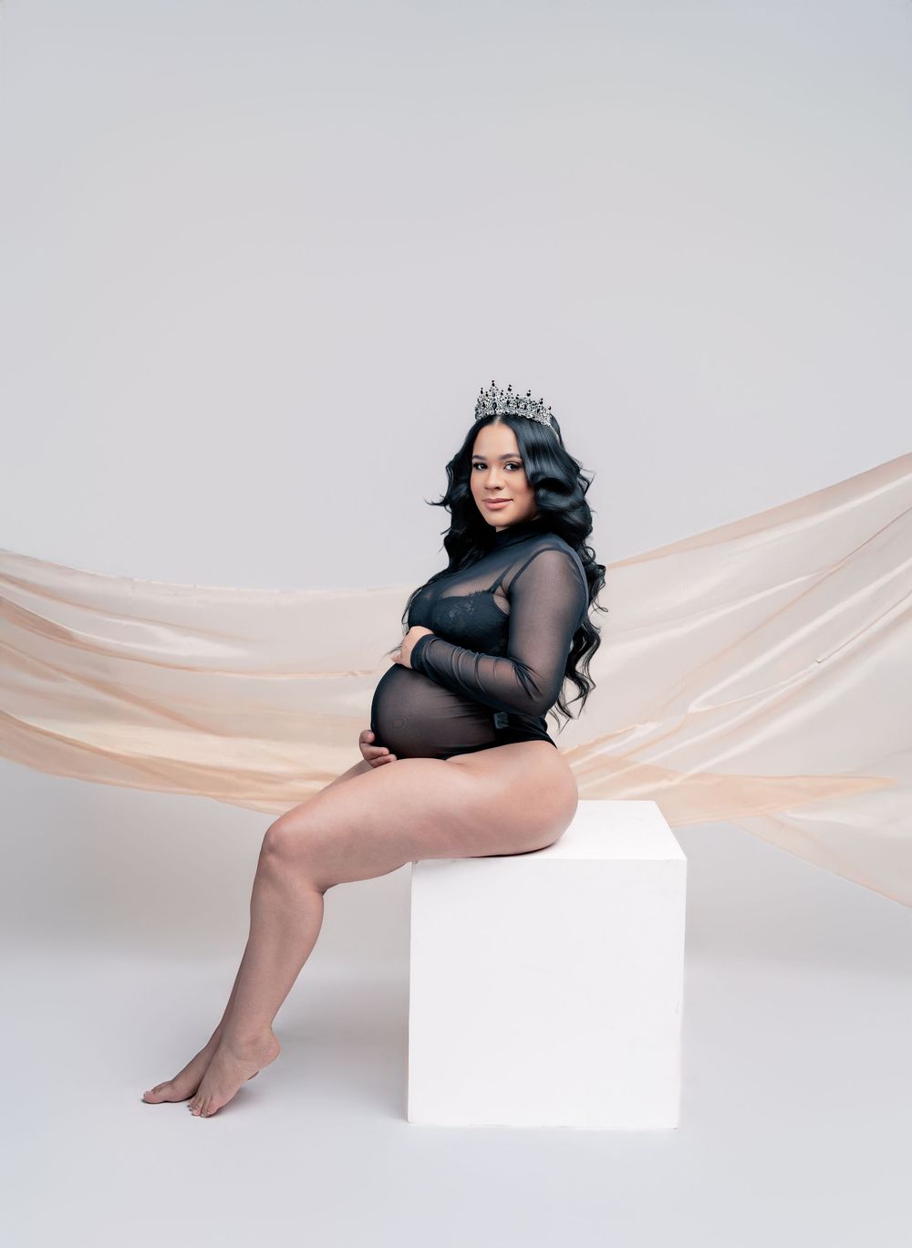 Artistic maternity photoshoot series with flowing peach fabric and white backdrop creating ethereal effect.