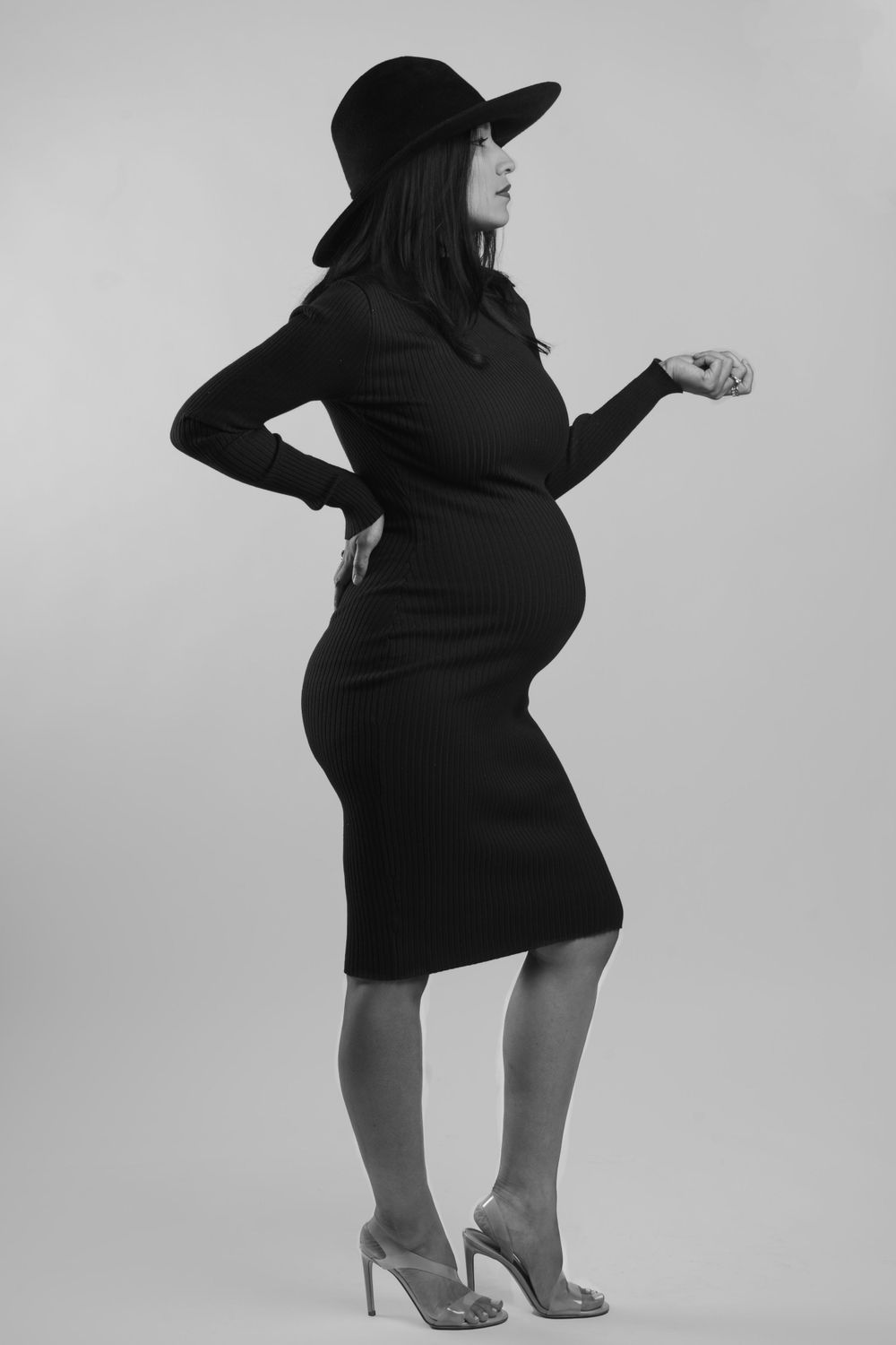 Black and white maternity fashion shoot with glamorous hat and high heels.