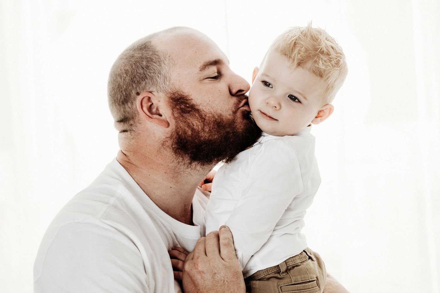 Tender moment shared between parent and child against white background.