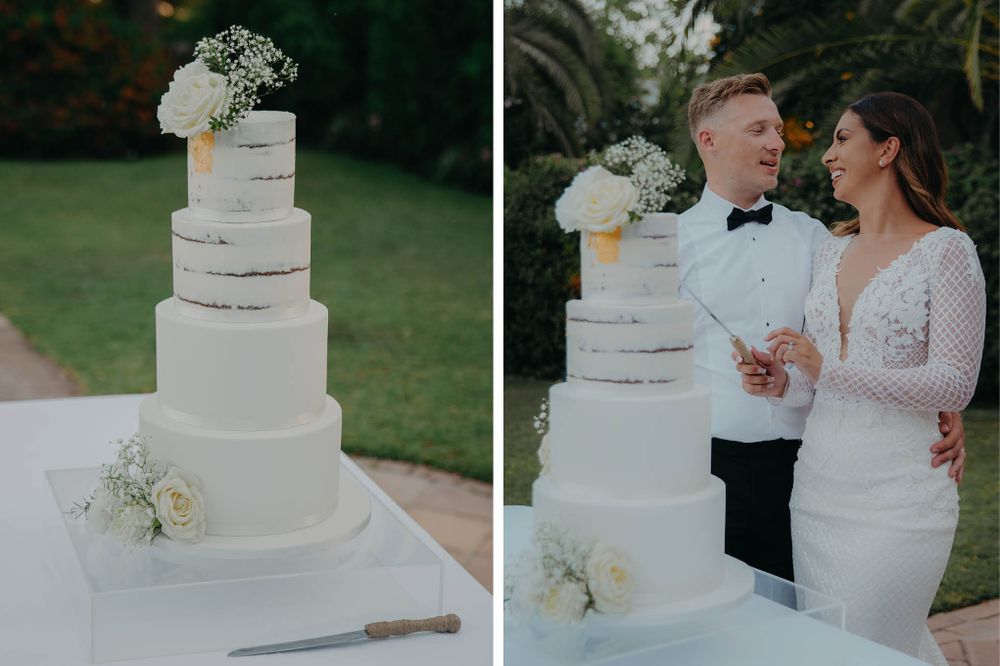 Elegant five-tier white wedding cake with floral decorations displayed outdoors.