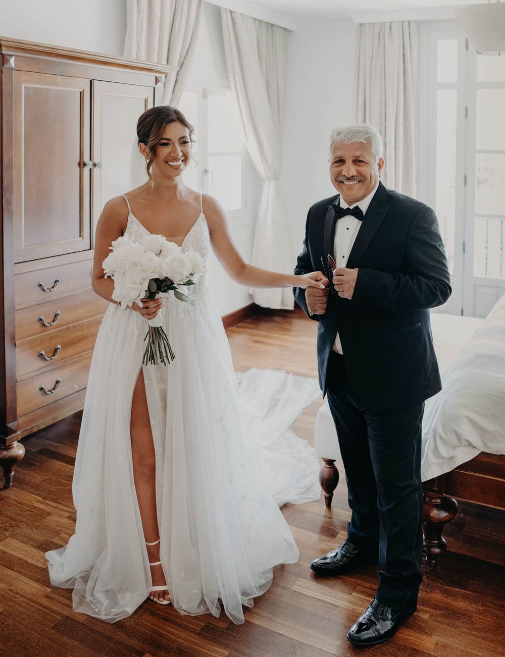 A touching wedding day moment captured in a bright room with hardwood floors.